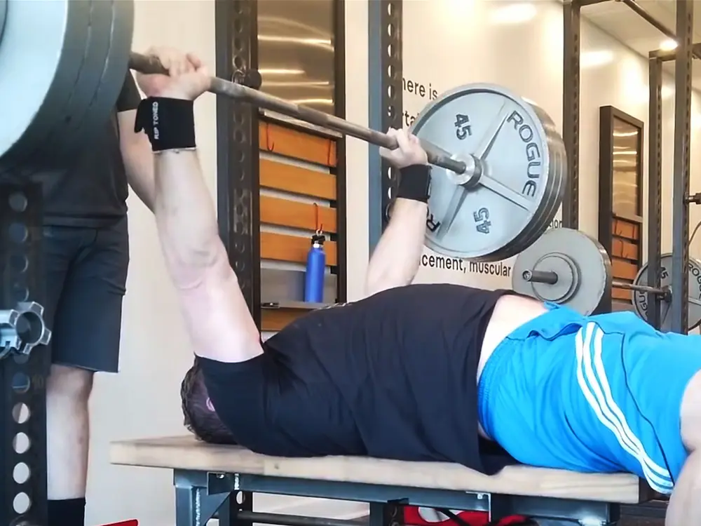 Starting Strength Gyms Coach teaching bench press to male client