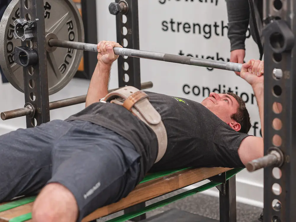 Athlete performing bench press at a Starting Strength gym