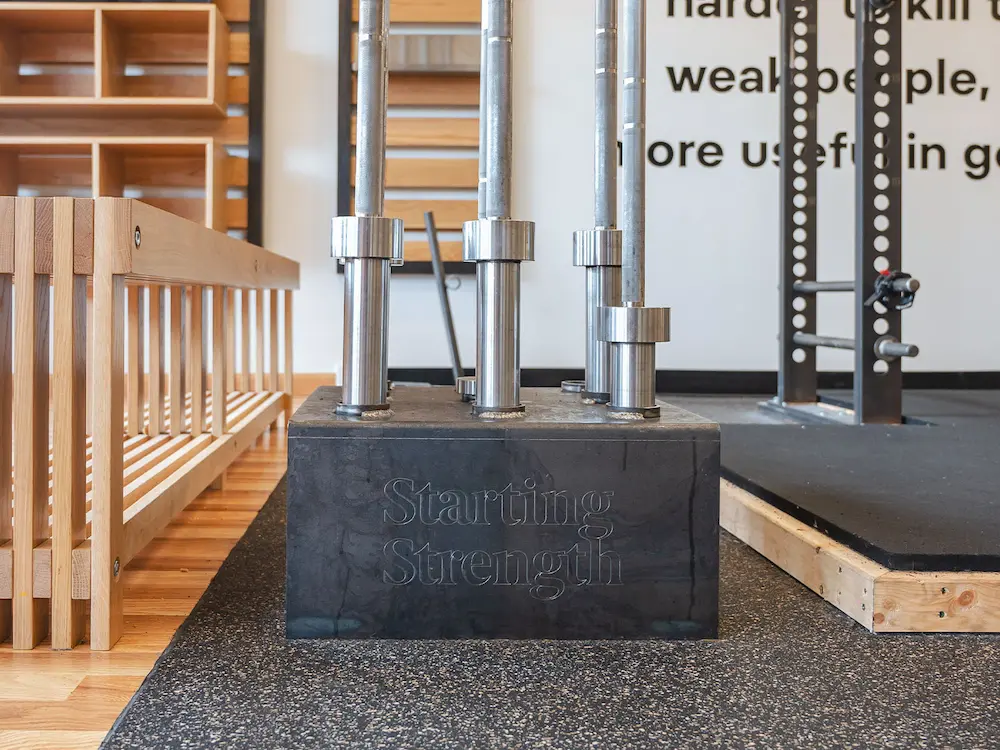 Custom Starting Strength branded barbell holder with barbells
