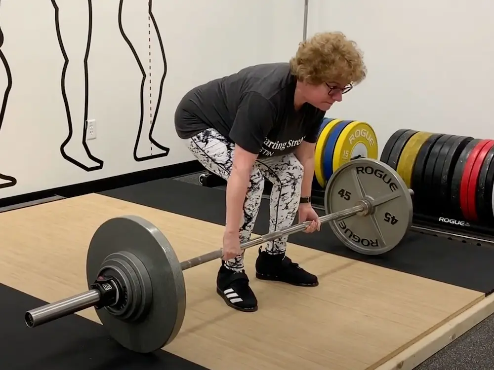 Young athlete performing deadlift setup with colorful patterned leggings