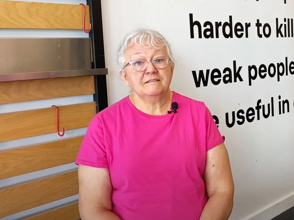 Senior female member Kathleen in pink shirt giving testimonial at Starting Strength gym